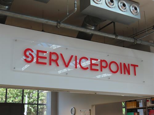 Foto: Nahaufnahme Schild Servicepoint über der Theke.