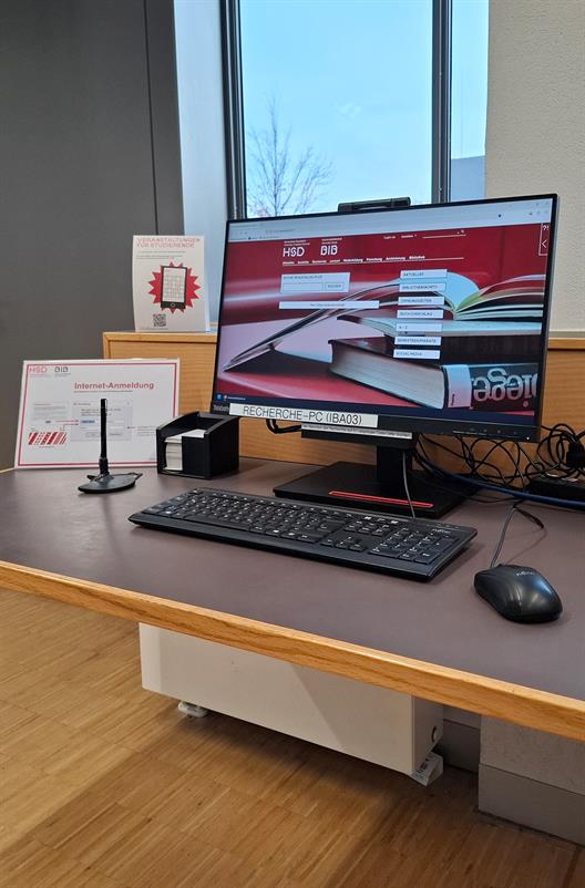 Ein PC, der den Startbildschirm der Bibliothekswebseite zeigt, steht auf einer Arbeitsfläche.